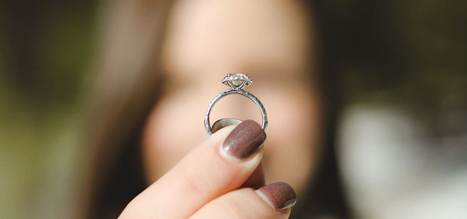 Chica  sosteniendo un anillo de diamantes